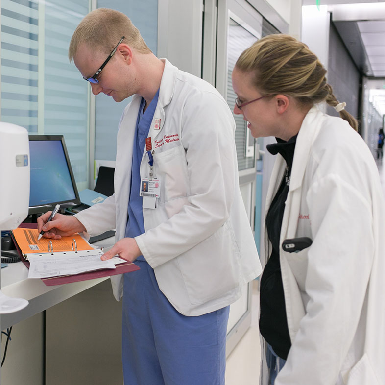 Two students reviewing a patient's chart.